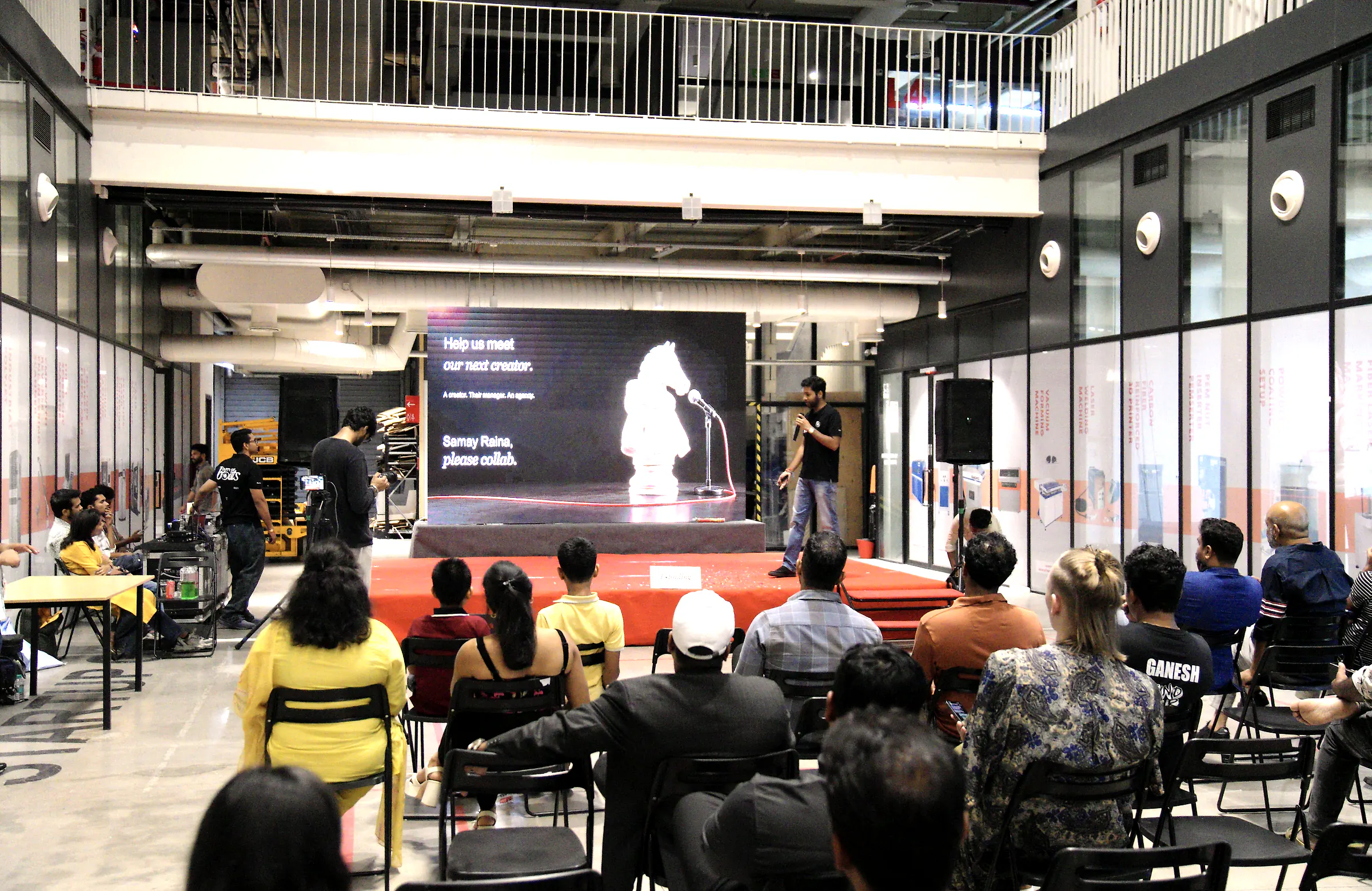 A full hall at T-Works watching a founder present on a large screen